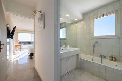 a white bathroom with a tub and a sink at 104 sqm Sea-View Apartment Cannes in Cannes