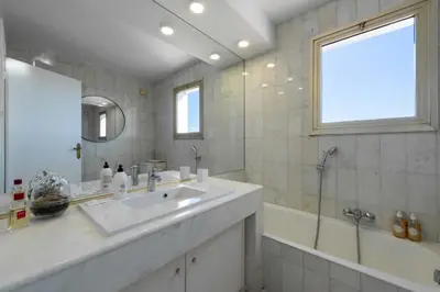 a bathroom with a sink and a tub and a mirror at 104 sqm Sea-View Apartment Cannes in Cannes