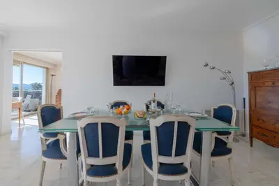 a dining room with a green table and chairs at 104 sqm Sea-View Apartment Cannes in Cannes