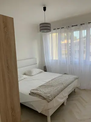 a bedroom with a bed with white curtains and a pendant at Elegance Cannoise, vaste terrasse in Cannes