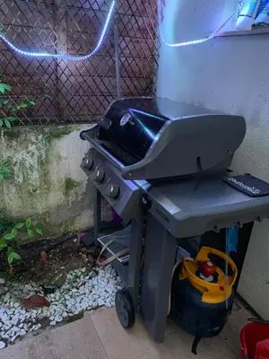 a grill sitting next to a fence in a backyard at Elegance Cannoise, vaste terrasse in Cannes
