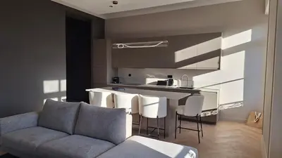 a living room with a couch and a kitchen at first louis marie Beautiful 3 bedrooms elegant and central in Cannes