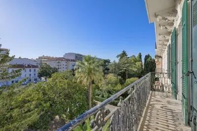 a balcony with a palm tree and buildings at first louis marie Beautiful 3 bedrooms elegant and central in Cannes