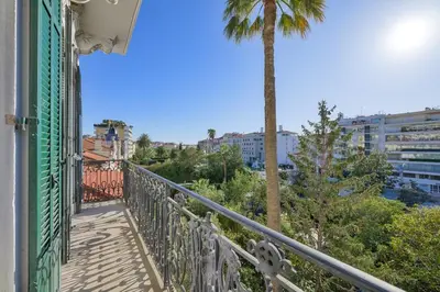 a balcony of a building with a palm tree at first louis marie Beautiful 3 bedrooms elegant and central in Cannes