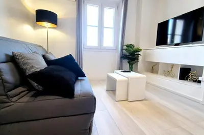 a living room with a couch and a flat screen tv at Charming one-bedroom flat on rue Hoche in Cannes