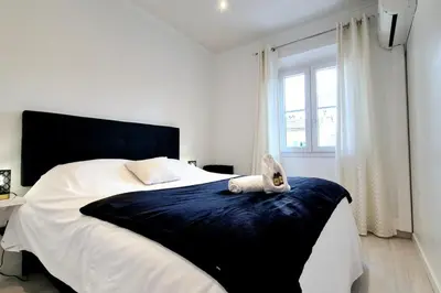 a bedroom with a bed with a cat sitting on it at Charming one-bedroom flat on rue Hoche in Cannes