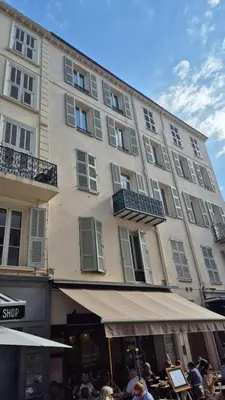 a large building with people sitting in front of it at Charming one-bedroom flat on rue Hoche in Cannes