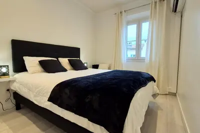 a bedroom with a large bed with a large window at Charming one-bedroom flat on rue Hoche in Cannes