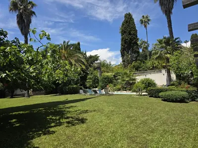 a large yard with palm trees and a fence at Villa Cannes in Cannes