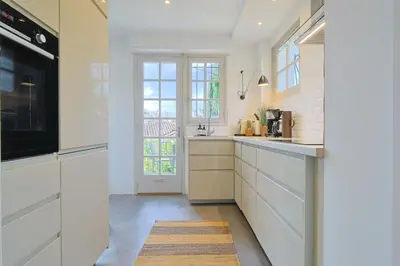 a kitchen with white cabinets and a large window at 221 Le Bella in Cannes