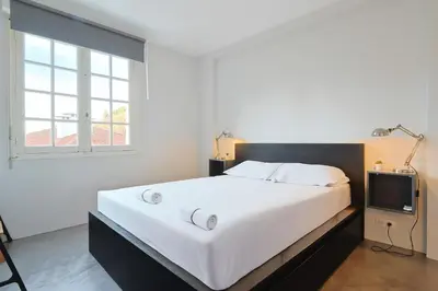a bedroom with a large white bed and a tv at 221 Le Bella in Cannes