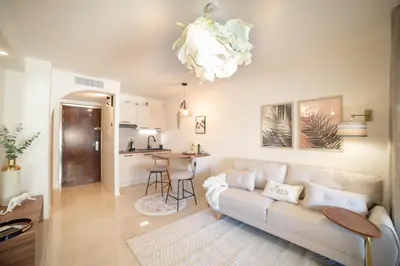 a living room with a couch and a kitchen at Le Charme YourHostHelper in Cannes