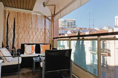 a room with chairs and a large window with a view at Le Charme YourHostHelper in Cannes