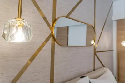 a mirror and a lamp on a wall at Le Charme YourHostHelper in Cannes