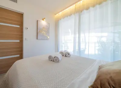 a bedroom with two towels on a bed with a window at Le Charme YourHostHelper in Cannes