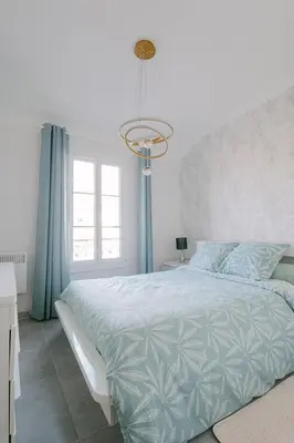 a bedroom with a large bed and a chandelier at Le Corail, Suquet pedestrian area, Cannes in Cannes