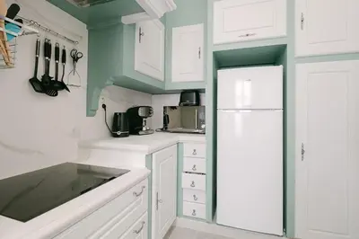 a kitchen with white cabinets and a white refrigerator at Le Corail, Suquet pedestrian area, Cannes in Cannes