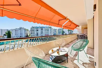 a balcony with a table and chairs on a building at Lacour - 2 bedroom apartment - Large terrace - 2 min from the Croisette & beaches in Cannes
