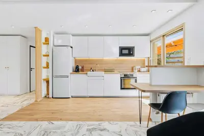 a kitchen with white appliances and a table and chairs at Lacour - 2 bedroom apartment - Large terrace - 2 min from the Croisette & beaches in Cannes