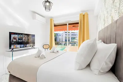 a bedroom with a large white bed with a window at Lacour - 2 bedroom apartment - Large terrace - 2 min from the Croisette & beaches in Cannes