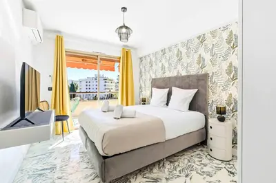 a bedroom with a large bed and a television at Lacour - 2 bedroom apartment - Large terrace - 2 min from the Croisette & beaches in Cannes