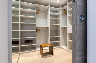 a walk in closet with a wooden stool and shelves at Luxury Two-Storey Villa with Pool & Rooftop Peaceful Setting Near Cannes in Cannes