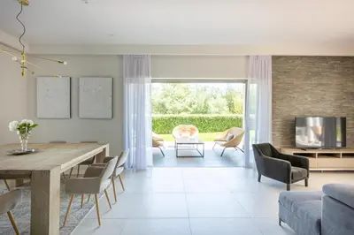 a living room with a table and chairs and a television at Luxury Two-Storey Villa with Pool & Rooftop Peaceful Setting Near Cannes in Cannes