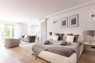 a white bedroom with a large bed and a living room at Luxury Two-Storey Villa with Pool & Rooftop Peaceful Setting Near Cannes in Cannes