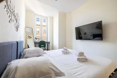 a white room with two beds and a flat screen tv at Modern Apartment a c 2CH 4P - Cannes in Cannes