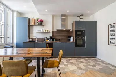 a kitchen with a wooden table and chairs in a room at Modern Apartment a c 2CH 4P - Cannes in Cannes