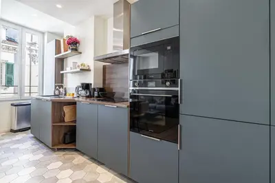 a kitchen with stainless steel appliances and gray cabinets at Modern Apartment a c 2CH 4P - Cannes in Cannes