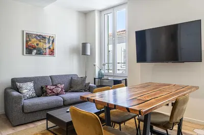 a living room with a table and a couch at Modern Apartment a c 2CH 4P - Cannes in Cannes