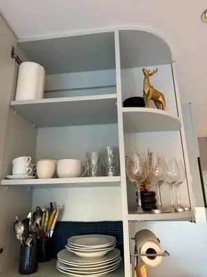 a white pantry with plates and wine glasses at Art apart studio Rouaze in Cannes