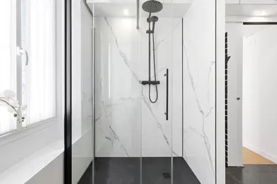 a glass shower in a bathroom with white walls at Riviera signature apartment by Welcome to Cannes in Cannes