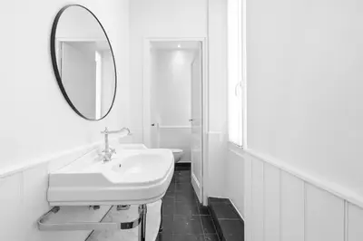 a white bathroom with a sink and a mirror at Riviera signature apartment by Welcome to Cannes in Cannes
