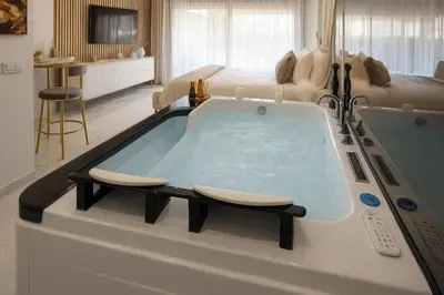 a large bath tub in a room with a bed at California Romantic Suite with Balneo in Cannes