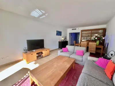 a living room with a couch and a tv at June apartment 2 bedrooms with pool in Cannes