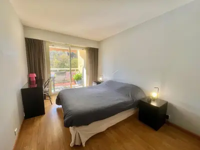 a bedroom with a bed with two night stands and a window at June apartment 2 bedrooms with pool in Cannes