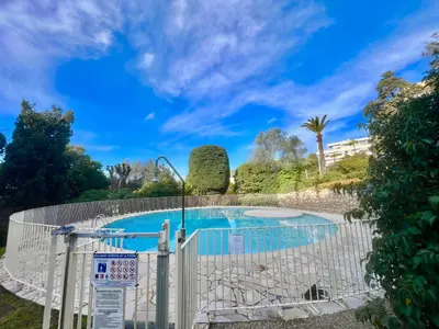 a swimming pool with a white fence around it at June apartment 2 bedrooms with pool in Cannes