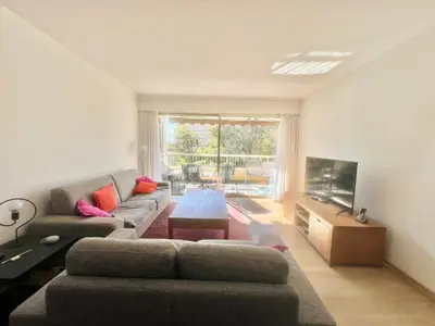 a living room with a couch and a tv at June apartment 2 bedrooms with pool in Cannes