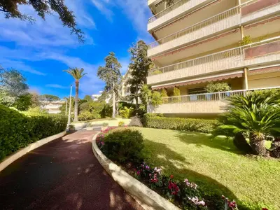 a building with a walkway in front of a yard at June apartment 2 bedrooms with pool in Cannes