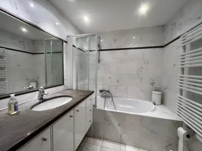 a white bathroom with a tub and a sink at June apartment 2 bedrooms with pool in Cannes