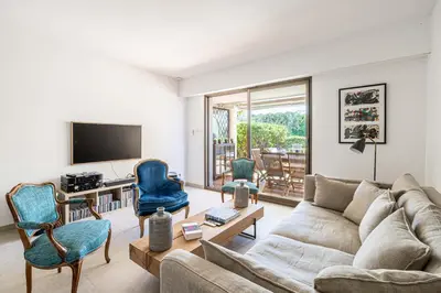 a living room with a couch and chairs and a tv at LE PARADIS avec deux terrasses équipées et piscine in Cannes