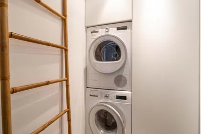 a laundry room with a washer and dryer at LE PARADIS avec deux terrasses équipées et piscine in Cannes