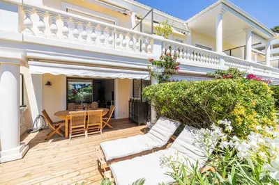 a house with a deck with a table and chairs at LE PARADIS avec deux terrasses équipées et piscine in Cannes