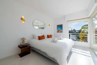 a white bedroom with a large bed and a window at 2-Br Sea-View Apartment Residence with Swimming Pool Cannes in Cannes