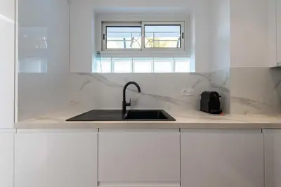 a white kitchen with a sink and a window at 2-Br Sea-View Apartment Residence with Swimming Pool Cannes in Cannes