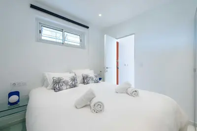 a white bedroom with a large white bed with towels on it at 2-Br Sea-View Apartment Residence with Swimming Pool Cannes in Cannes