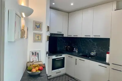 a kitchen with white cabinets and a bowl of fruit at Cozystay 1825 Luxury Duplex on Rue dAntibes in Cannes