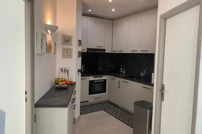 a kitchen with white cabinets and a black counter top at Cozystay 1825 Luxury Duplex on Rue dAntibes in Cannes
